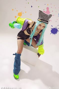 a woman with blue hair and green eyes is posing on a white box wearing fishnet stockings