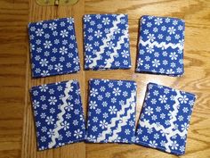 four pieces of blue and white fabric with flowers on them, sitting on a wooden surface