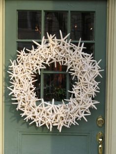 a white wreath is hanging on the front door