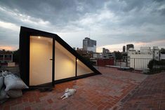 a dog laying on the ground in front of a building with a pitched roof and windows