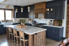 a kitchen with blue cabinets and white counter tops, wooden flooring and stools