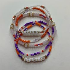 Set Of Five Handcrafted Beaded Bracelets Celebrating College Spirit! Each Bracelet Showcases Vibrant School Colors And Is Personalized With Your College's Name. Perfect Accessory To Flaunt Your School Pride Or A Thoughtful Gift. Embrace Your College Journey With These Stylish And Meaningful Bracelets! Cheap School Spirit Bracelets For Game Day, School Spirit Beaded Bracelets, College Bracelet Stacks, Adjustable Purple Beaded Bracelets With Letter Beads, Back To School Bracelets, Adjustable Purple Letter Beads Bracelet, Clemson Bracelet, Lsu Bracelet, Sports Bracelet