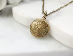 "This little locket necklace is made with a 15mm round, antiqued bronze floral locket, perfect to hold tiny photos, and it hangs on an 18-inch antiqued bronze cable chain with a lobster clasp. This lovely Victorian necklace makes the perfect romantic jewelry gift for her. Thank you for looking. NOTE: Gemsicles' gold-filled, rose/gold-plated, antiqued, silver and rhodium jewelry is cadmium-free, lead-free and nickel-free. Also, our plated jewelry is dipped in a special coating to help prevent tar Antique Gold Bohemian Locket Necklace, Adjustable Antique Gold Necklace With Vintage Charm, Bohemian Brass Locket Necklace, Adjustable Antique Gold Locket Jewelry, Antique Gold Locket Jewelry For Vintage Collection, Nickel-free Bronze Brass Locket Necklace, Bronze Pendant Locket Necklace With Antique Finish, Bronze Antique Finish Locket Pendant Necklace, Victorian Round Necklace With Antique Finish