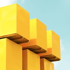 an abstract photograph of yellow boxes against a blue sky