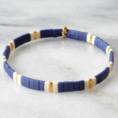 Like little works of art you can wear, these stretch tila bead tile bracelets — all in exclusive Libby & Smee patterns — are perfect on their own or worn in sets. Stacking is strongly encouraged.Style: NAVY PATTERN - Navy, ivory and gold+ glass and gold-plated tile beads on two stretch cords+ closures are finished with gold-plated crimp covers (lead-free and nickel-free)+ comes in one 7" size to fit most wrists+ all Libby & Smee beaded bracelets come packaged in a clear resealing bag for Navy Blue Tile, Tila Bead Bracelets, Tile Bracelets, Tila Bracelets, Tile Bracelet, Tila Beads, Loom Bracelet Patterns, Wood Bead Bracelet, White Bracelet