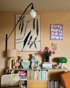 a living room filled with furniture and a painting on the wall above it's bookshelf