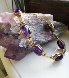 "A sumptuous antique Art Deco bracelet, housing the most beautifully intense cabochons of amethyst. Most probably created in the 1920s era in Germany, as 8ct gold (often stamped \"333\" as in this case) was used there quite a lot in the first decades of the twentieth century. It screams the Art Deco designs of the era, both in its use of those parallel strips of gold as connectors between each large cabochon and also its use of purple in these wonderful stones. I love this bracelet- it wears so Formal Purple Oval Cabochon Jewelry, Vintage Purple Oval Cabochon Jewelry, Formal Amethyst Jewelry, Oval Cabochon, Antique Purple Bracelets For Formal Occasions, Formal Round Amethyst Bracelets, Formal Amethyst Round Bracelets, Formal Amethyst Bracelets, Antique Oval Gemstone Bracelets, Formal Amethyst Oval Cabochon Jewelry