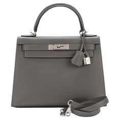 Hermes brand new Kelly 28 in Gris Mouette epsom leather with brushed palladium hardware and tonal stitching. It comes with a two strap with front toggle closure, clochette with lock and two keys, single rolled handle and removable shoulder strap. The interior has one zip pocket with Hermes engraved pull and two open pockets on the opposite side. Hermes Grey Bag, Hermes Clothes, Kelly Hermes, Hermes Kelly 25, New Money, Hermes Kelly Bag, Grey Bag, Girly Bags, Kelly Bag