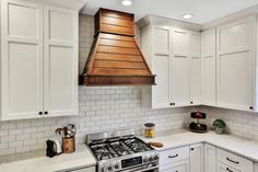 a stove top oven sitting inside of a kitchen next to white cupboards and counter tops