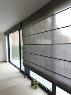 a living room with large windows and blinds on the side of the window sill