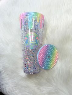 the starbucks cup has been decorated with colorful sequins and is next to a hair brush