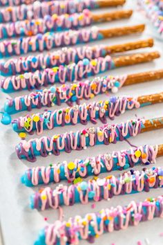 many colorful donuts are lined up on a table with sprinkles and confetti