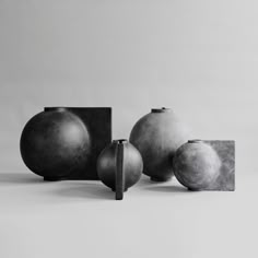 three black and white vases sitting next to each other