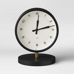 a black and white clock sitting on top of a table