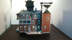 a paper model of a red brick building with windows and balconies on top