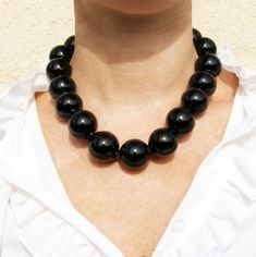 Bubble necklace made of 15 black hollow opaque glass beads. A black satin ribbon is threaded and gives elegance and originality to this wonderful necklace. It is made of Effetre Murano glass. Others colors or bead size on request. It is safely packed in a gift box. Size of beads: 28mm Ribbon 15cm from the neck. All of our glass is handmade in our Asolo studio. Each piece is kiln-annealed at F1050 degrees for strength and durability. Colors may vary on different computer monitors and in different Black Beaded Necklace With Large Beads For Formal Occasions, Formal Black Necklace With Large Beads, Elegant Black Necklaces With Large Beads, Black Glass Beaded Necklaces, Black Glass Bead Necklace, Black Glass Beaded Necklace, Black Round Glass Necklaces, Adjustable Black Beaded Glass Necklace, Bubble Necklace