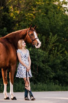 a woman standing next to a brown horse