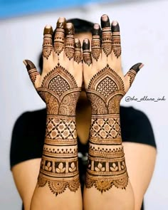 a woman's hands with henna tattoos on them