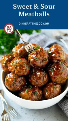 a white bowl filled with meatballs covered in sauce and garnished with parsley