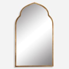 a gold framed mirror with an arched design on the top and bottom, against a white wall