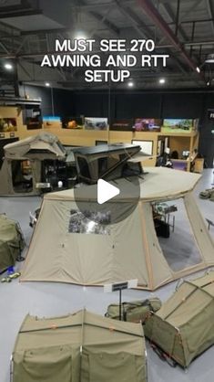 an army tent set up in the middle of a room with other tents and equipment