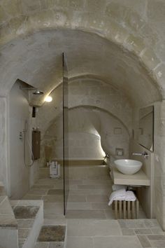 a large bathroom with stone walls and flooring