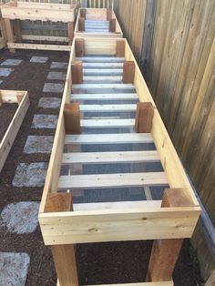 an outdoor garden area with raised planters and wooden steps leading up to the top