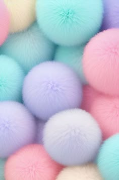 pastel colored pom - poms are piled up in the same color scheme