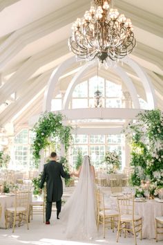 a bride and groom walking down the aisle at their wedding reception in an elegant venue