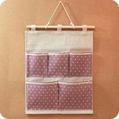 a pink and white polka dot pocket hanging on a wall