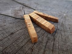 three pieces of wood sitting on top of a piece of wood that has been cut in half