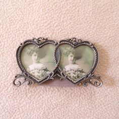 two heart shaped brooches with an image of a woman