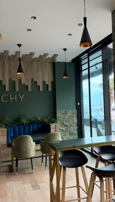 an empty restaurant with wooden tables and stools in front of a window that reads rich chy