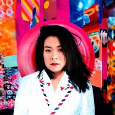 a woman with black hair wearing a white shirt and red hat in front of colorful art