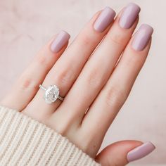 a woman's hand with pink manicured nails and a ring on her finger