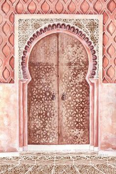 an ornate door with intricate carvings on the outside and inside, is shown in pink tones