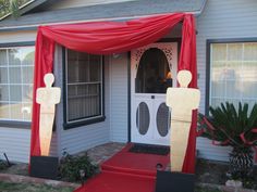 the front entrance to a house decorated with red curtains