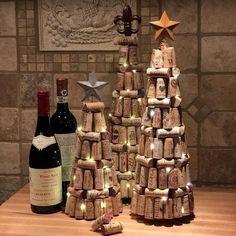 two wine bottles are stacked on top of each other in front of a cork christmas tree