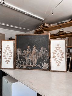 three framed pictures sitting on top of a table