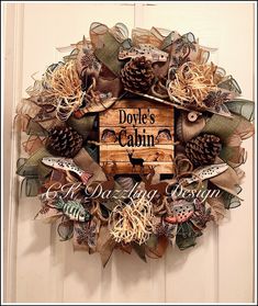 a wreath that has some pine cones and other things on it with the words dole's cabin