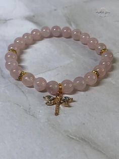 Rose Quartz Dragonfly 8mm gemstone charm bracelet with gold spacers. Size 7in (Large) & 7.5in (X-Large) available.  Created by Aesthetic Gems by Asia Janae - Aesthetic bracelets created to compliment your beautiful soul. Each bracelet is made with love, good energy, and high vibes. Rose Quartz Bracelet Aesthetic, Crystal Bracelets Aesthetic, Crystal Bracelet Ideas, Aesthetic Bracelets, Bracelets Aesthetic, Bracelet Aesthetic, Bracelet Inspo, Dragonfly Charm, Rose Quartz Bracelet