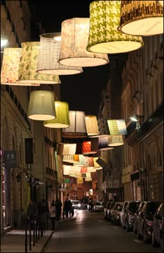 many lamps hanging from the ceiling in an alley way