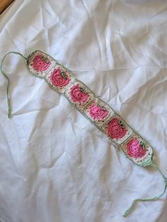 a crocheted object is laying on a white sheet