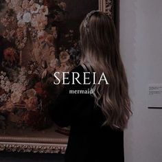 a woman standing in front of a painting with the words sereia on it