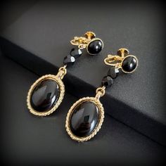 Vintage Accessocraft black gold dangle earrings, long black oval clip-on earrings Metal:gold-tona Stone: black glass beads, black plastic cabochons, faux onyx Size - 2 3/8'' Mark: Accessocraft NY.C Circa: before the 2000s earrings Condition - very good PLEASE NOTE: Vintage jewelry can show signs of wear and discoloration or chipped metal consistent with age. Please look at the pictures carefully. Most were purchased at estate sales, auctions, etc. so they could need cleaning. If you need additional pictures or have questions, please contact me prior to purchase. I am not a jeweler or an expert. I do the best I can to research and represent the items. Also on auction purchases, I use the information I get from the auction houses. If you have any questions or need additional pictures, please 2000s Earrings, Classic Black Clip-on Earrings, Designer Black Clip-on Earrings, Black Vintage Round Clip-on Earrings, Black Vintage Clip-on Earrings, Luxury Vintage Black Clip-on Earrings, Long Black, Gold Earrings Dangle, Black Glass