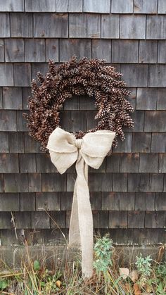 a wreath on the side of a building with a bow hanging from it's front