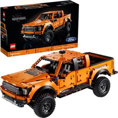 an orange toy truck is in front of a box