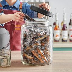 a woman is holding a jar full of screws