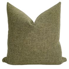 a green pillow sitting on top of a white table