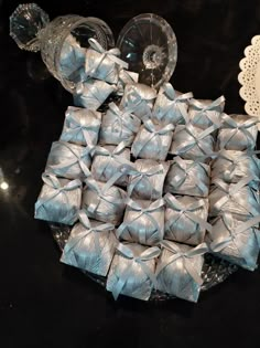 a table topped with lots of silver wrapped presents